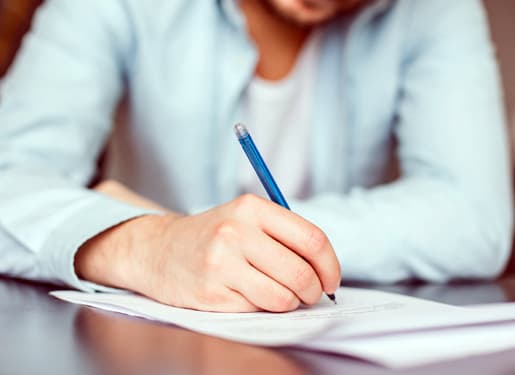 homme avec un stylo écrivant sur une feuille Europ Assistance