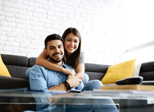 couple heureux assis sur un canapé Europ Assistance